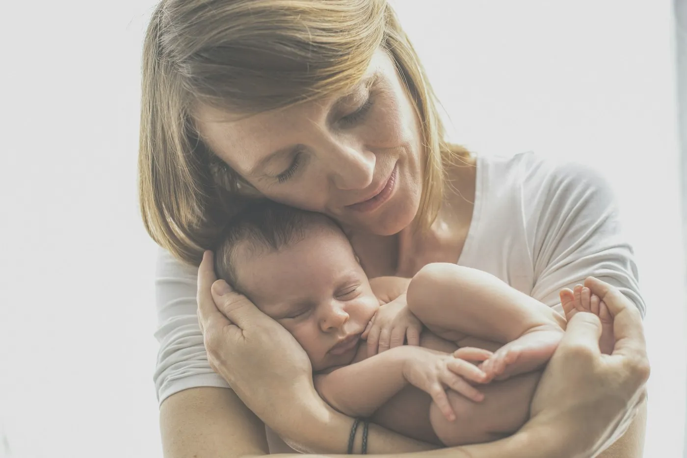 A mother holding her newborn close