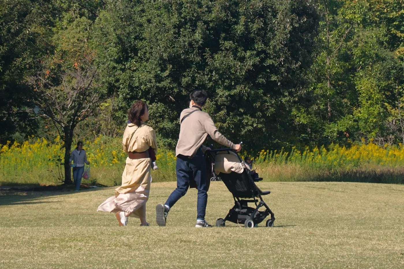 A parent walking with a stroller outdoors